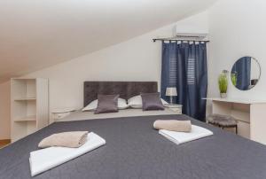 a bedroom with a large bed with two pillows on it at Apartman MG Makarska in Makarska