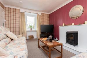 a living room with a couch and a fireplace at The Auld Sweetie Shop in Perth