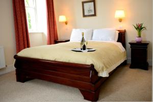 a bedroom with a bed with a bottle of wine on it at Ashbrook Arms Townhouse and Restaurant in Durrow +10 photos