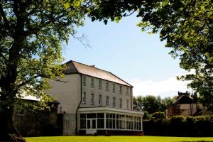 ein großes weißes Gebäude mit einem großen Fenster in der Unterkunft Ashbrook Arms Townhouse and Restaurant in Durrow