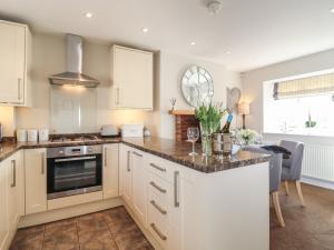 a kitchen with white cabinets and a counter top at Foxy Cottage in Harrogate
