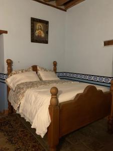 1 cama en un dormitorio con una foto en la pared en Copper Canyon Riverside Lodge en Batopilas