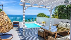 a patio with a table and a swimming pool at Panorama Suites & Spa - Adults Only in Stomio