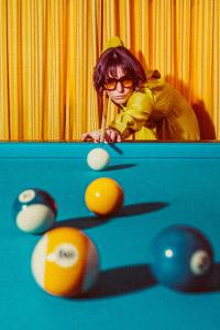 a woman playing a game of snooker with a cue at Amadeus Ora & Amore in Caldaro