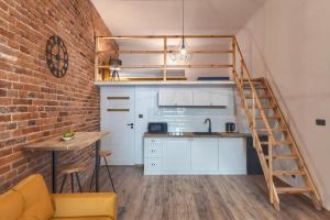 une cuisine en mezzanine avec un escalier et un mur en briques dans l'établissement Aparts by Hostly, à Cracovie
