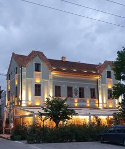 Un grand bâtiment blanc avec des lumières sur lui dans l'établissement Conacul Sfântul Sava Brancovici, à Ineu