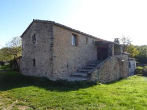 un ancien bâtiment en pierre avec des escaliers dans un champ dans l'établissement Gîte de Navacelles, à Blandas