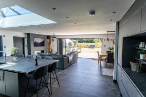 an open kitchen and living room with a table and chairs at Wood View Barn in Iron Acton