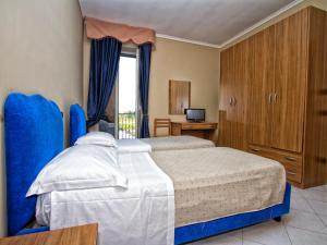 a bedroom with a bed and a desk and a television at Hotel Silverado in Aversa