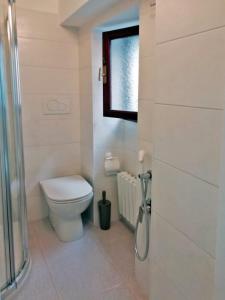 ein Bad mit einem WC und einem Fenster in der Unterkunft Appartamento Cristina in Stresa