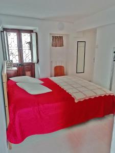 a bedroom with a red bed with a red blanket at Appartamento Cristina in Stresa