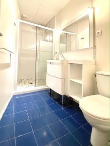 bagno con doccia e pavimento piastrellato blu di QUERTINEUX Historic 4 Châteaux Lastours 3 Star 3 BED air conditioned apartment a Lastours