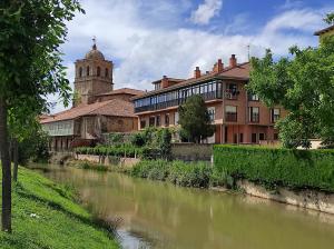 un río frente a un edificio con iglesia en Apto. Completo, La Ribera, en Aguilar de Campóo