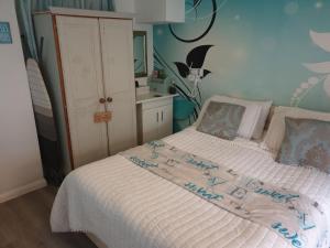 トーキーにあるSelf Contained Rooms in Central Torquayのベッドルーム1室(白いシーツと青い壁のベッド1台付)