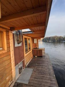 un ponte di legno di una barca su un corpo d'acqua di Hausboot mit Hottub in Berlin a Berlino