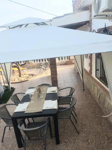 - Balcón con mesa y sillas y dosel blanco en Villa Capricho Nerja, en Málaga