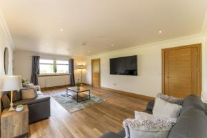 a living room with a couch and a tv at Higginsneuk in Airth
