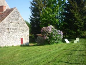 a field with two benches in front of a stone building at Maison de ferme rénovée en pierre avec jardin, cheminée, WIFI, équipements bébé, animaux acceptés - FR-1-489-19 in Ébreuil +7 photos