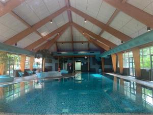 a large swimming pool in a building with a ceiling at GREEN VILLA in bester Lage - Dachterrasse mit Meerblick - großer eingezäunter Garten - kinderfreundlich - Hunde inklusive - 4 Sterne Resort - direkt am Strand - Pool inklusive in Hulshorst