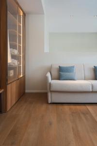 uma sala de estar com um sofá e pisos em madeira em Doria Park Hotel em Lerici
