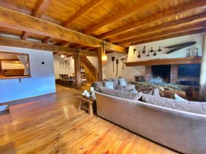 a living room with a large couch and a fireplace at Pleta Ordino 18, Duplex rustico con chimenea, Ordino, zona vallnord in Ordino