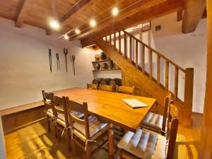 a dining room with a wooden table and chairs at Pleta Ordino 18, Duplex rustico con chimenea, Ordino, zona vallnord in Ordino