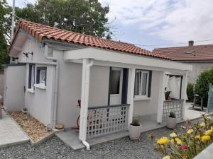 a small white house with a porch at Studio à la campagne avec piscine partagée et jardin - FR-1-489-230 in Vendat