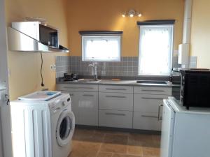a kitchen with a washing machine and a washer at Studio à la campagne avec piscine partagée et jardin - FR-1-489-230 in Vendat