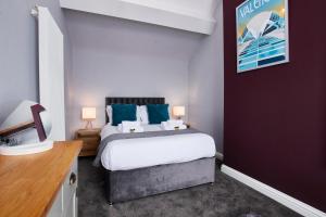 a bedroom with a large bed with blue pillows at Delven House, Apartment 6 in Castle Donington