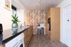 a kitchen with a sink and a dishwasher at The Auld Sweetie Shop in Perth