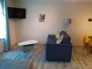 sala de estar con sofá azul y mesa en Les appartements du Saint Hubert en Arcis-sur-Aube