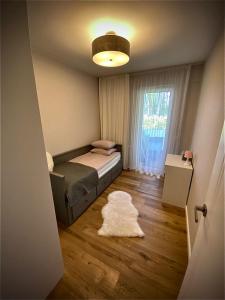 a bedroom with a bed and a window and a rug at Apartament w obiekcie Platinum Rewal in Rewal