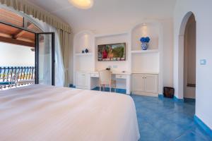 Schlafzimmer mit einem Bett, einem Schreibtisch und einem Balkon in der Unterkunft Grand Hotel Le Rocce in Gaeta