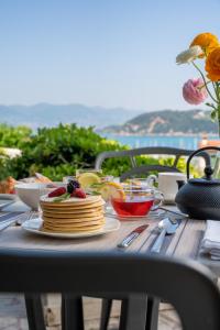 una mesa con desayuno de tortitas y fruta en Doria Park Hotel en Lerici