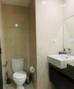 a bathroom with a white toilet and a sink at Josh's Place at One Eastwood Avenue Tower 1 in Manila