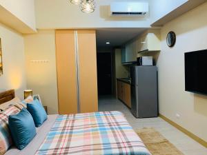 a small bedroom with a bed and a refrigerator at Josh's Place at One Eastwood Avenue Tower 1 in Manila