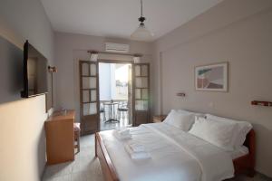 a bedroom with a large white bed with white sheets at Pomelo Rooms in Parga