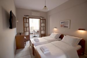 a hotel room with two beds and a balcony at Pomelo Rooms in Parga