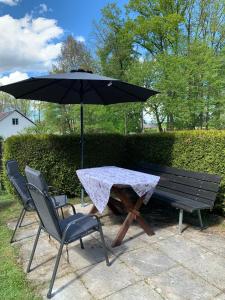 a picnic table with an umbrella and two chairs at Chalupa u rybníka in Libín
