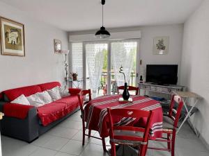 a living room with a red couch and a table at Charmant T2, centre Cambo, calme, Tt confort, terrasse, parking, proche commerces - FR-1-495-5 in Cambo-les-Bains