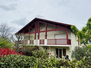 a white and red house with a balcony at Appartement Cambo-les-Bains, 2 pièces, 2 personnes - FR-1-495-8 in Cambo-les-Bains