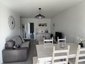 a living room with a couch and a table at Appartement T2 confortable avec terrasse sud et parking, au calme, proche commerces, petit animal accepté - FR-1-495-6 in Cambo-les-Bains +11 photos