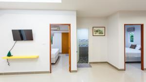 a room with a bed and a tv and a bathroom at Bangtao Local House Rental in Bang Tao Beach