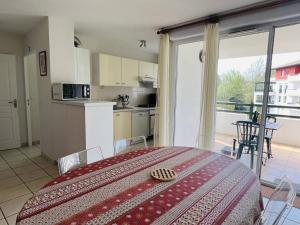 a room with a kitchen and a table with a bed at Appartement Cambo-les-Bains, 2 pièces, 3 personnes - FR-1-495-9 in Cambo-les-Bains