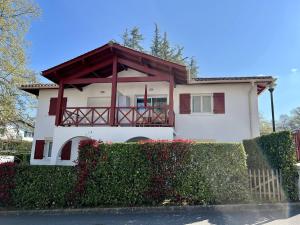 a white house with a porch and a fence at Appartement Cambo-les-Bains, 2 pièces, 4 personnes - FR-1-495-13 in Cambo-les-Bains