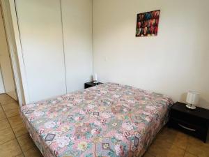 a bedroom with a bed with a quilt on it at Appartement F2 à Cambo-les-Bains avec piscine, proche thermes, terrasse et parking - FR-1-495-36 in Cambo-les-Bains