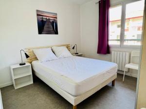 a bedroom with a bed and a picture of a pier at Appartement Cambo-les-Bains, 2 pièces, 2 personnes - FR-1-495-46 in Cambo-les-Bains
