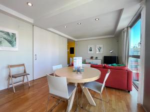 sala de estar con mesa y sofá rojo en Stay U-nique Apartments Degà Bahí en Barcelona