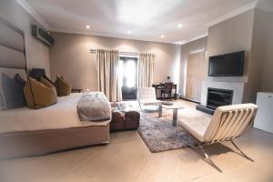 ein Schlafzimmer mit einem Bett und ein Wohnzimmer mit einem Kamin in der Unterkunft The Capital Guest House in Gaborone