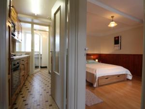 um pequeno quarto com uma cama e uma cozinha em Gîte Vrigny (Orne), 2 pièces, 2 personnes - FR-1-497-32 em Vrigny